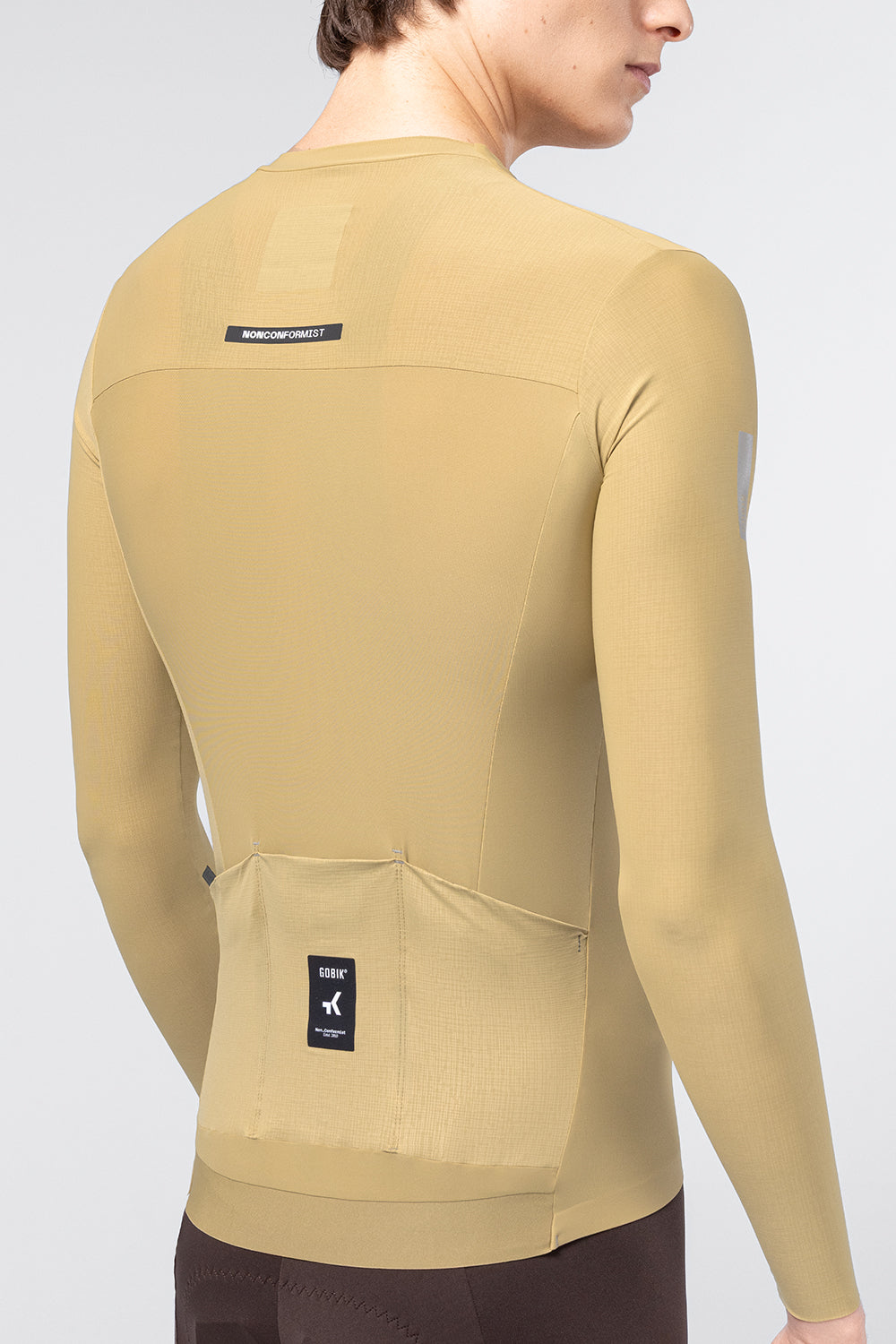 Gobik Avalon Long Sleeve Jersey Keemun color on male model, rear view showing back pockets