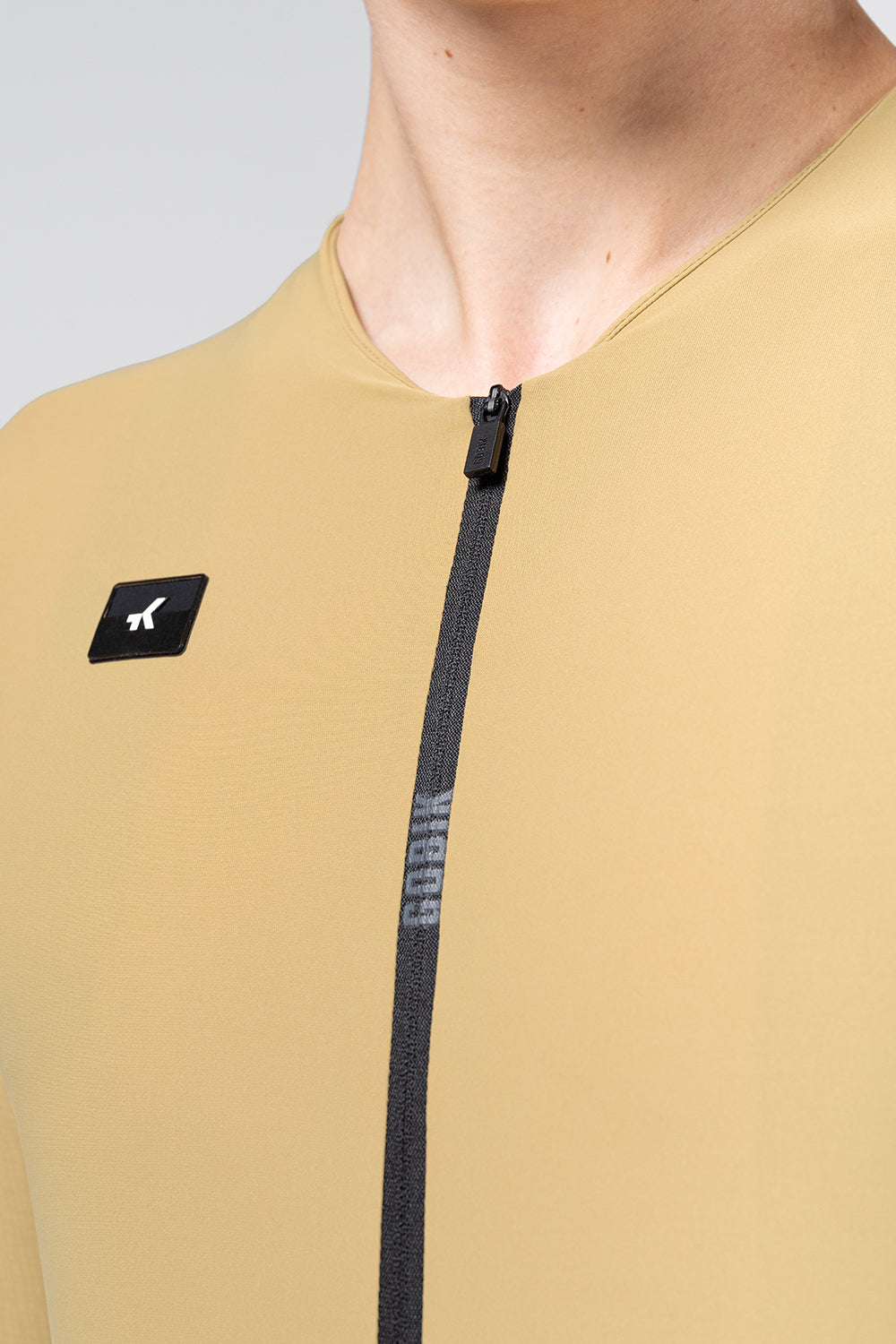 Close-up detail of Gobik Avalon jersey zipper and brand logo badge in Keemun color