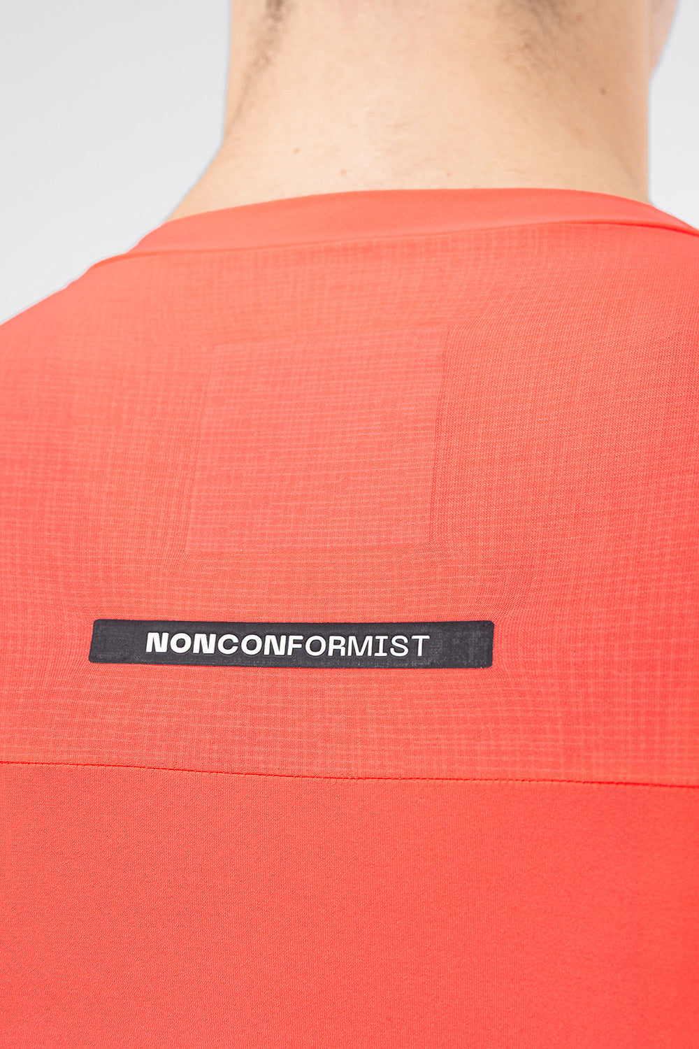 Close-up of Gobik Avalon jersey back showing Nonconformist label and ripstop fabric panel in lava