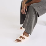 Person wearing Birkenstock Arizona EVA sandals in light rose with double buckle straps
