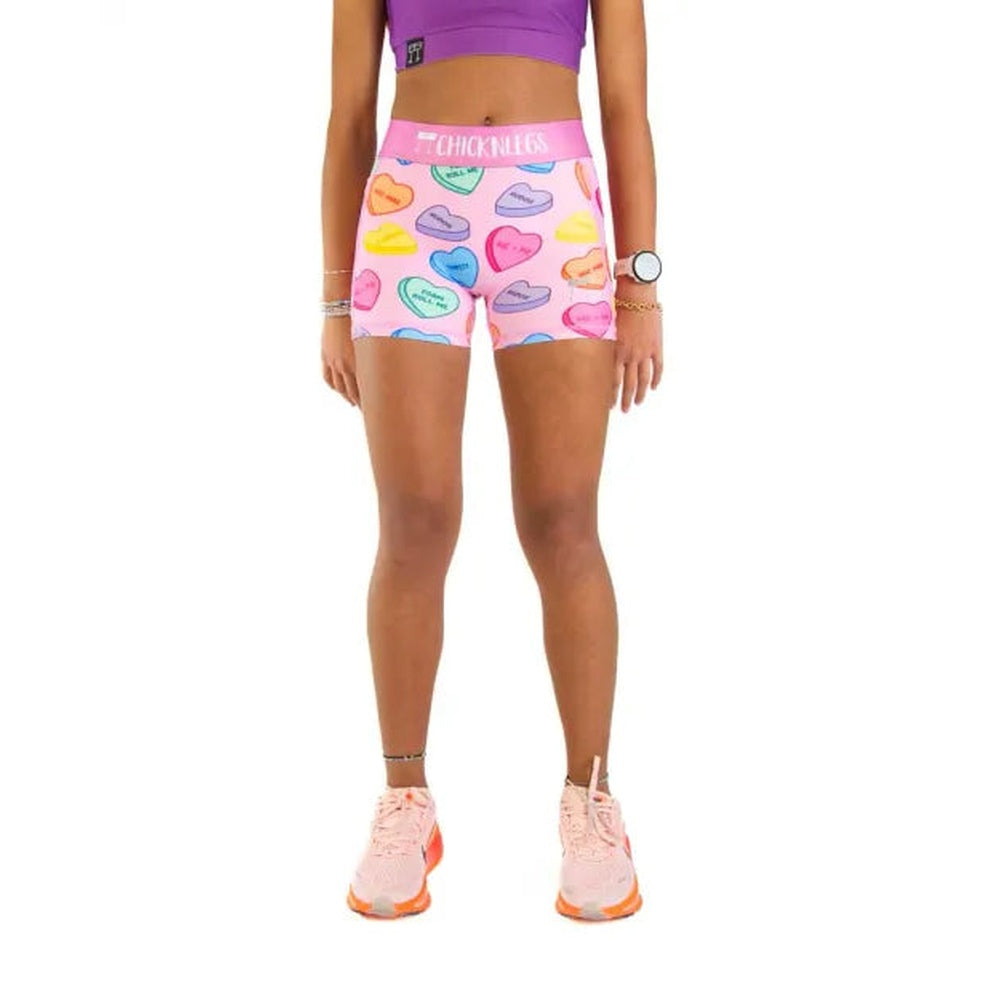 Woman wearing pink compression shorts with colorful candy heart pattern