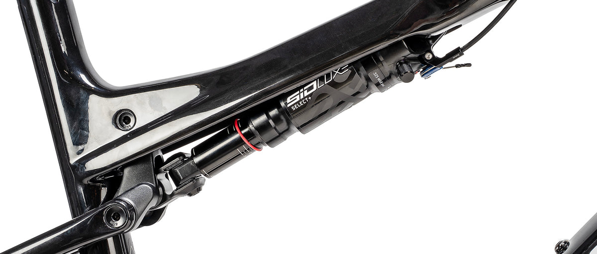 Close-up detail of RockShox SID LUX Select+ rear shock on Specialized Epic 9 carbon frame
