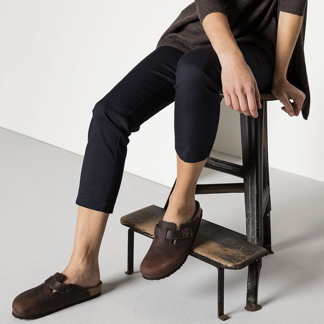 Person wearing Birkenstock Boston clogs in dark brown oiled leather while sitting