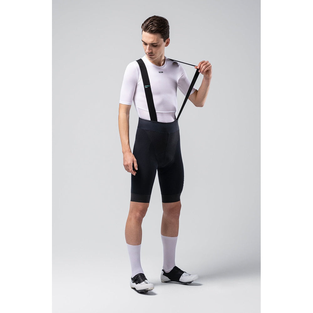 Man wearing black Gobik X bib shorts with suspenders and white cycling jersey