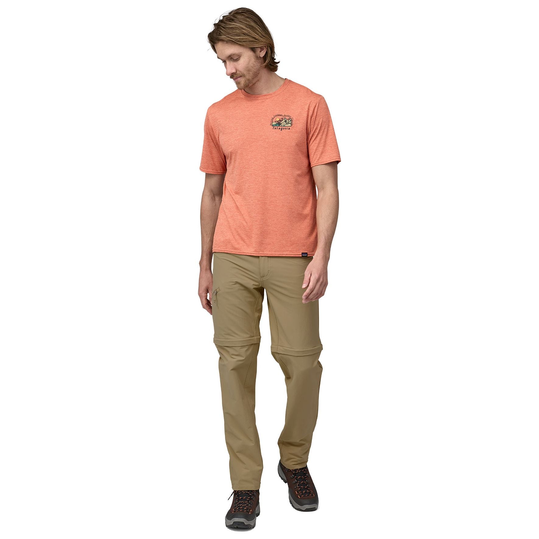 Man wearing Patagonia Quandary convertible pants in classic tan with orange shirt