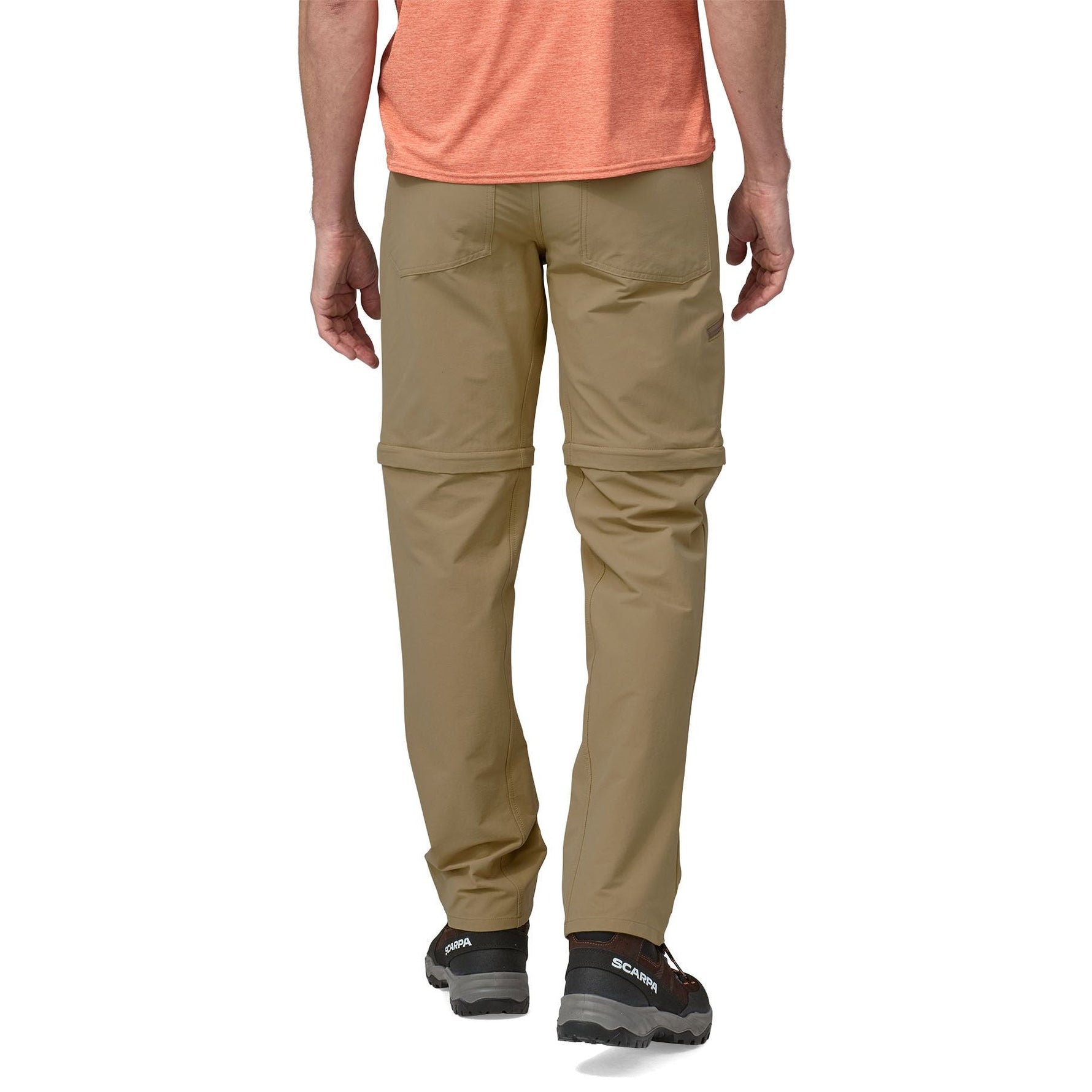 Man wearing Patagonia Quandary convertible pants in classic tan, rear view showing zip-off design