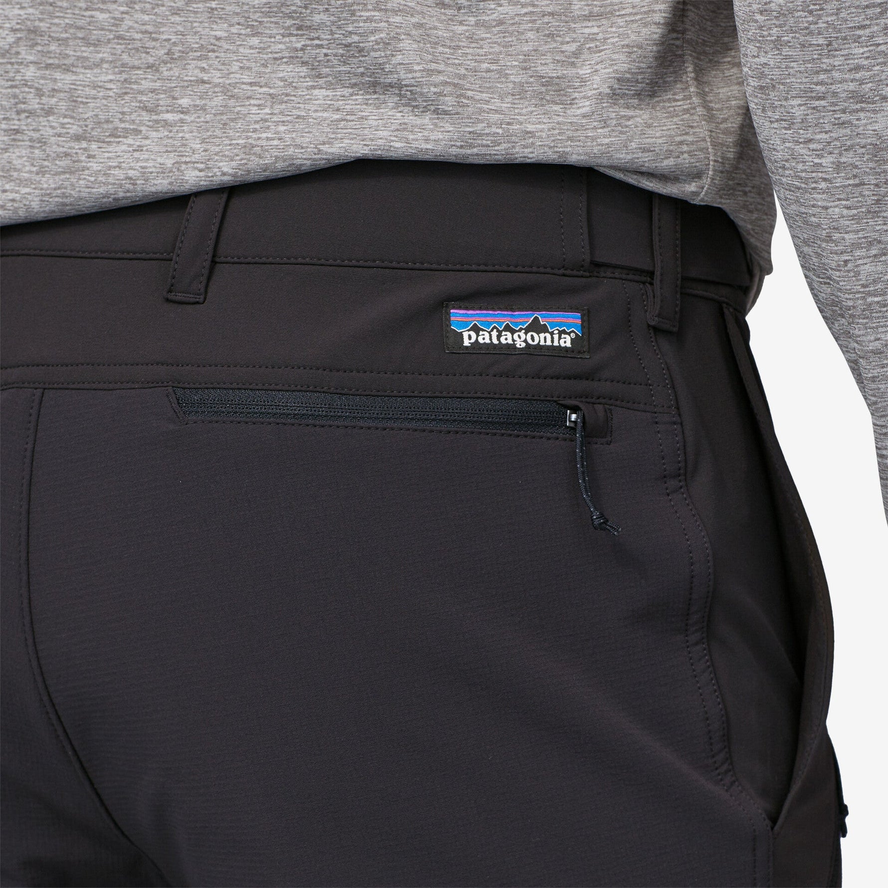 Close-up of black Patagonia trail pants showing waistband, pocket, and brand logo