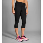 Woman wearing black Brooks Greenlight capri leggings with mesh panel details