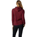 Back view of woman wearing cranberry Fox Racing pullover hoodie with black pants