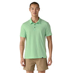 Man wearing light green Patagonia polo shirt with khaki shorts on white background