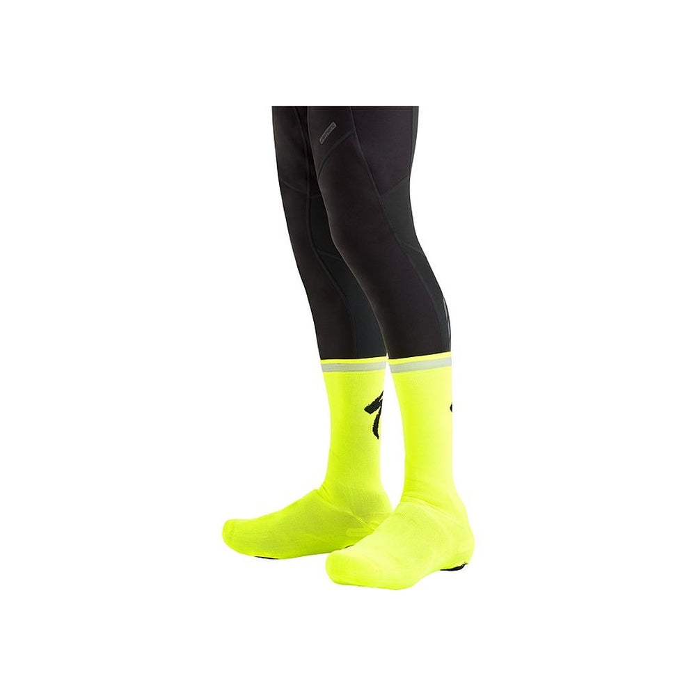 Specialized Reflect Overshoe Socks in neon yellow worn over black cycling tights