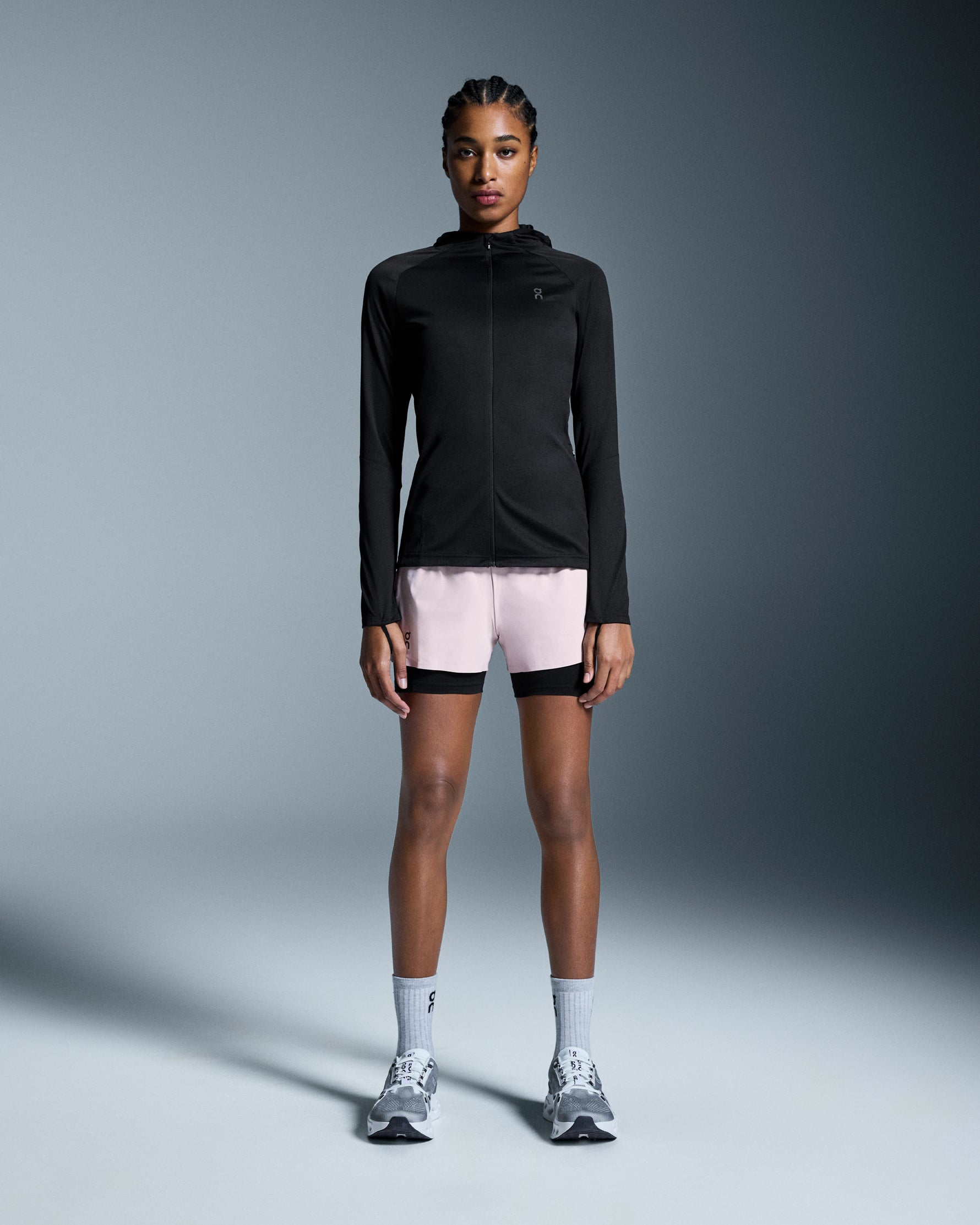 Woman wearing On 3-inch Performance 2-in-1 shorts in mauve and black with matching jacket