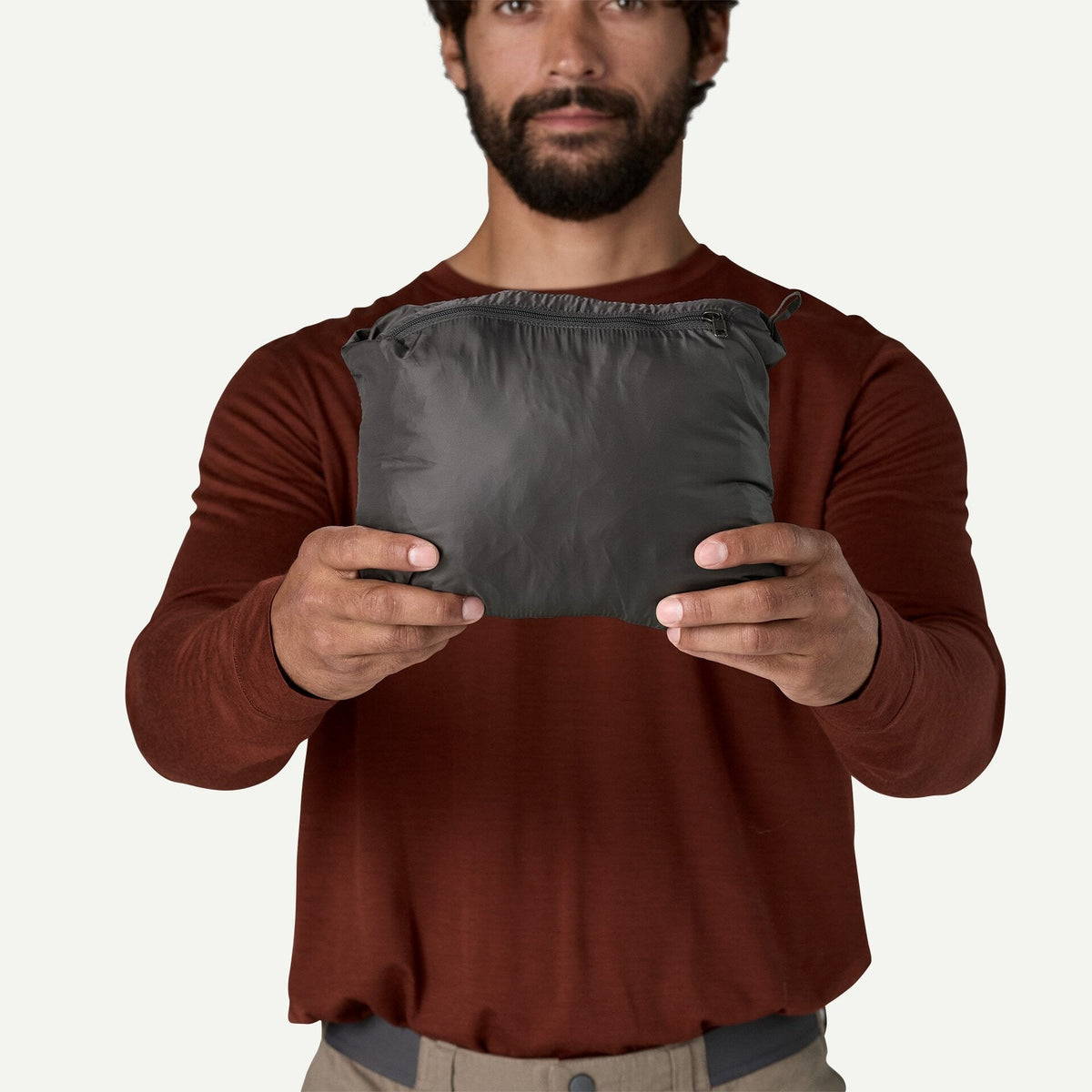 Patagonia Nano Puff Jacket packed into its own pocket in Forge Grey, compact size shown
