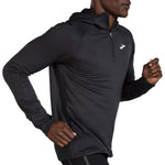 Man wearing Brooks Notch Thermal Hoodie in heather ash gray with quarter-zip