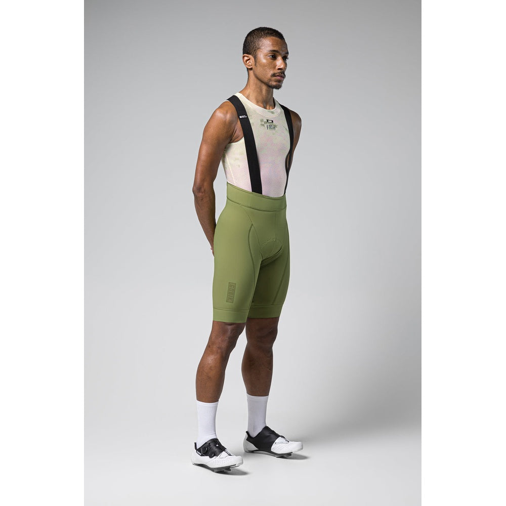 Male cyclist wearing Gobik Matt Men's Bibshort in timber green with mesh base layer