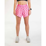 Woman wearing pink polka dot athletic shorts with ChicknLegs branding
