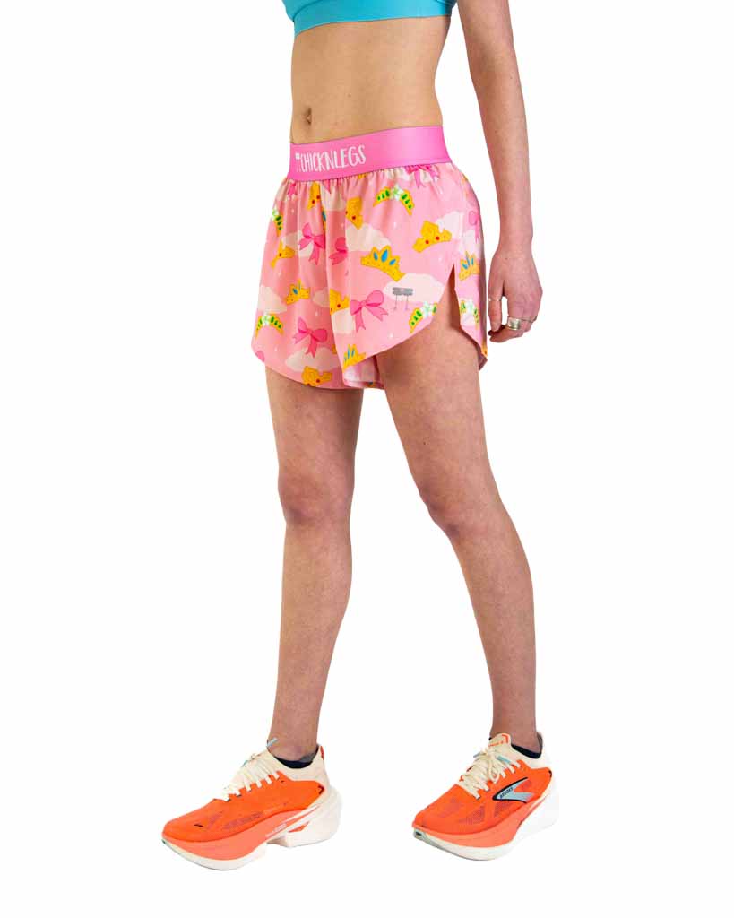 Woman wearing pink ChicknLegs split shorts with princess tiara pattern and orange sneakers