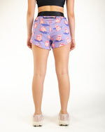 Purple athletic shorts with pink pig pattern worn by model from behind