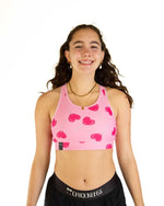 ChicknLegs OG Sports Bra in Luv Pops pink heart lollipop print on smiling model