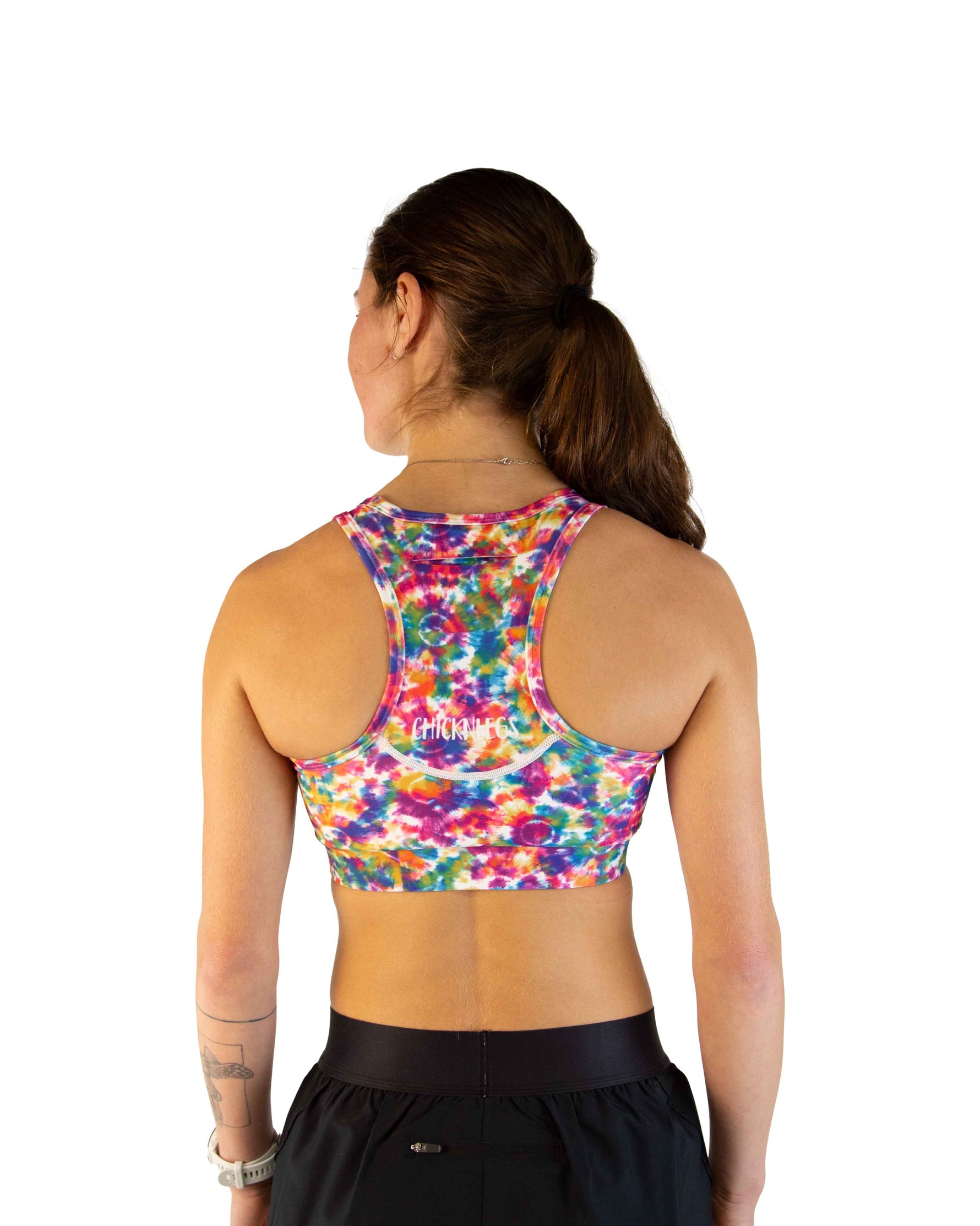 Back view of woman wearing ChicknLegs tie-dye racerback sports bra with multicolor pattern