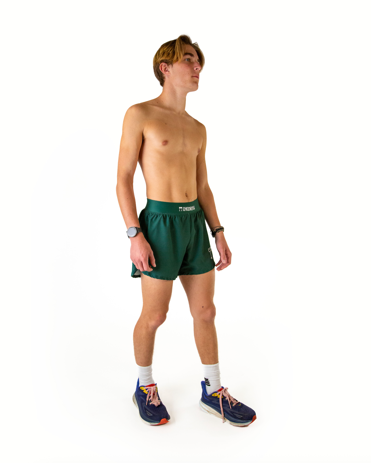 Male model wearing forest green athletic shorts with split hem design