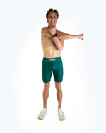 Man wearing ChicknLegs forest green 8-inch half tights in studio photo