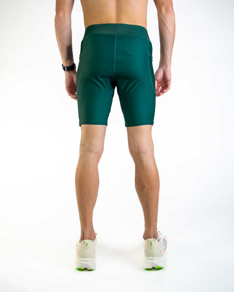 Back view of man wearing forest green athletic compression shorts in studio setting
