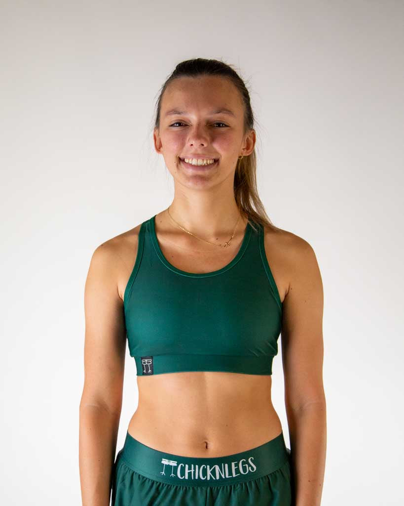 Woman wearing ChicknLegs forest green sports bra and shorts athletic set