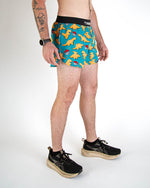 Man wearing blue shorts with orange dinosaur and pokeball print pattern
