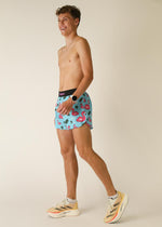 Man wearing ChicknLegs flamingo print shorts in light blue with pink flamingos