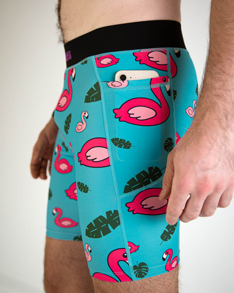 Men's turquoise compression shorts with pink flamingo and tropical leaf print pattern