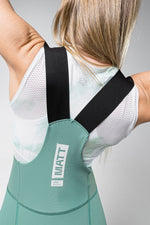 Woman wearing Gobik Matt 2.0 women's bib shorts in sage green with black straps