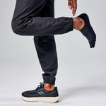 Model wearing Feetures Elite Light Cushion Invisible black no-show socks with New Balance sneakers