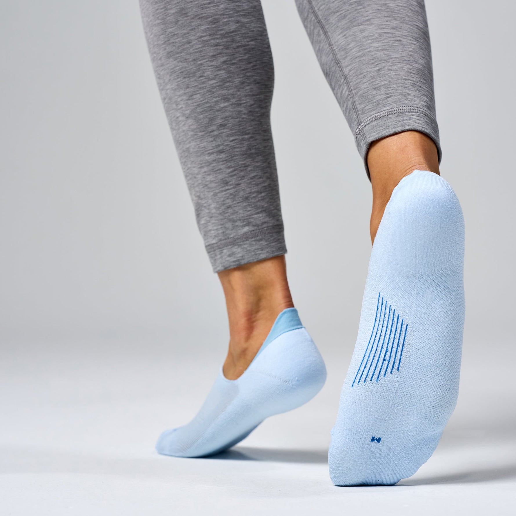 Feetures Elite Light Cushion Invisible no-show socks in Ice blue on model feet