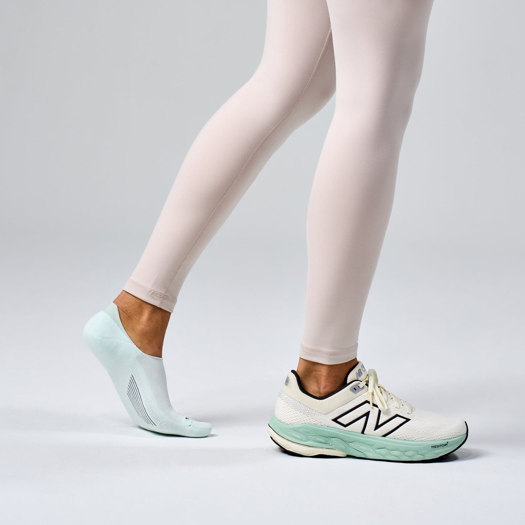 Feetures Elite Light Cushion Invisible sock in Ice color worn with New Balance sneakers