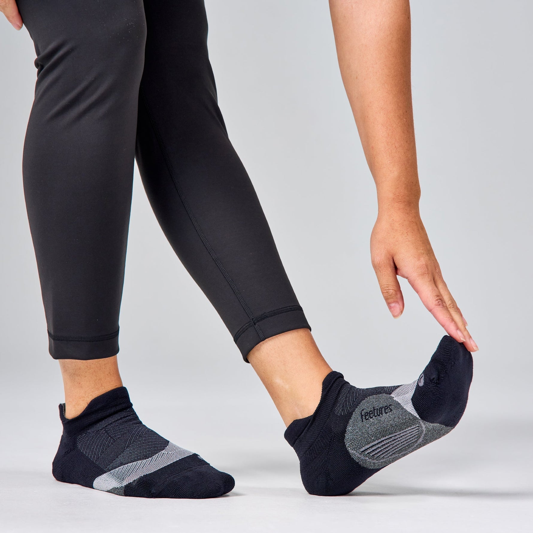 Feetures Elite Light Cushion Tab socks in black and grey worn during exercise