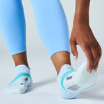 Person wearing Feetures Elite Light Cushion Tab socks in mint chip colorway with blue leggings