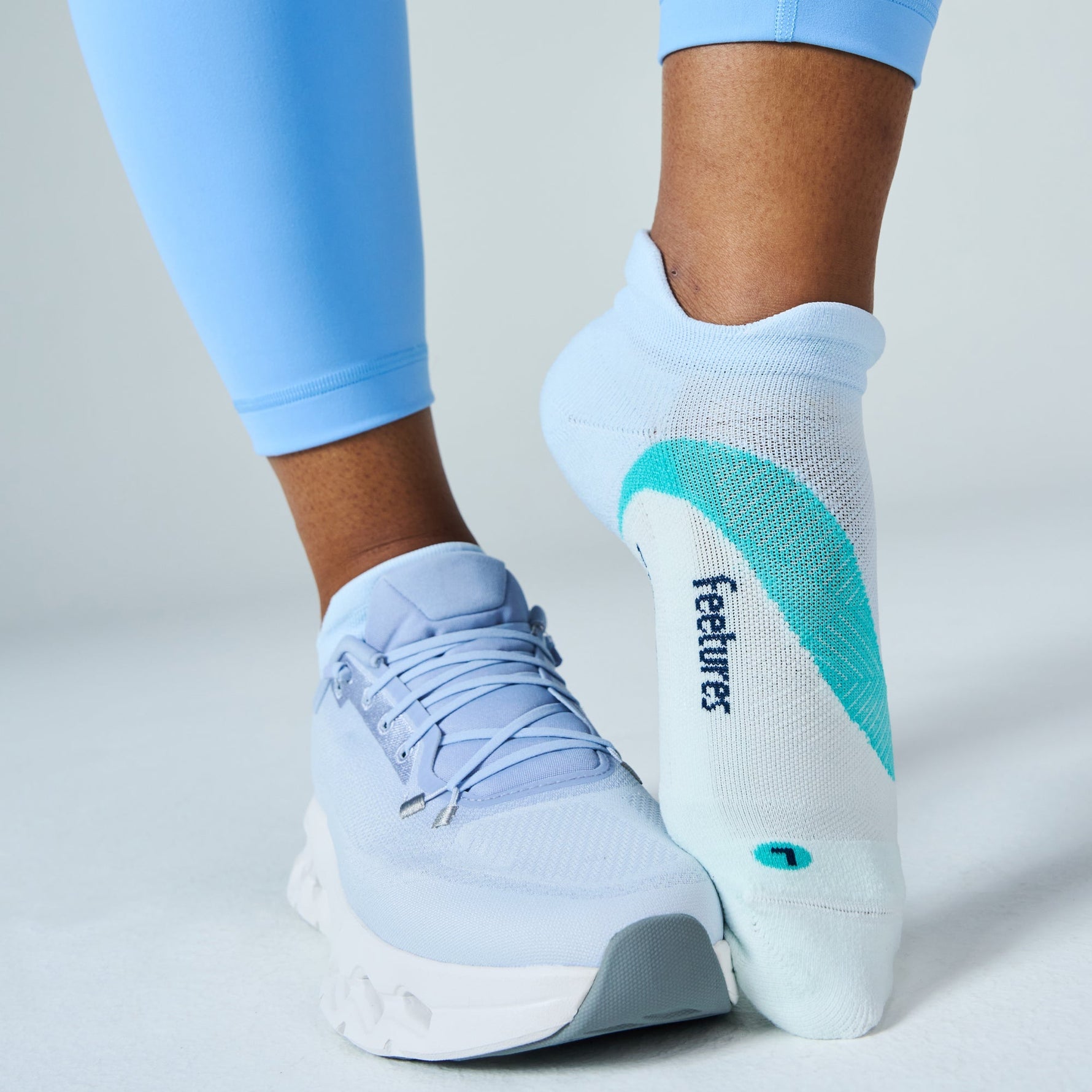 Feetures Elite Light Cushion Tab socks in Mint Chip worn with light blue sneakers