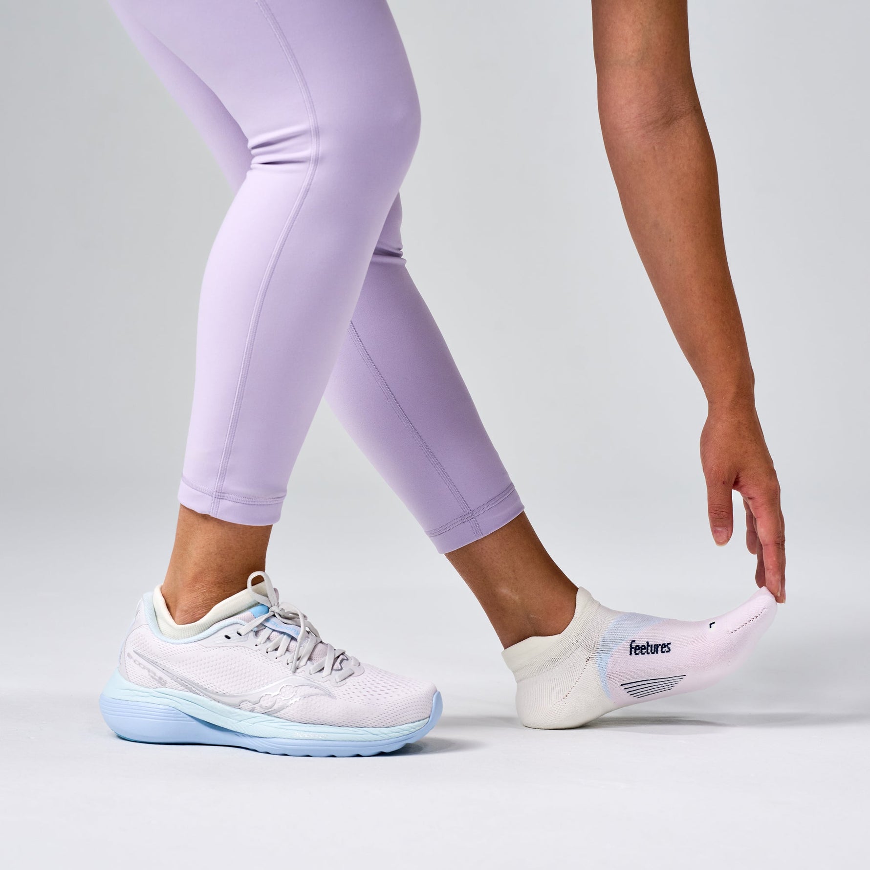 Feetures Elite Light Cushion Tab no-show socks in Lilac Breeze colorway on model wearing running shoes