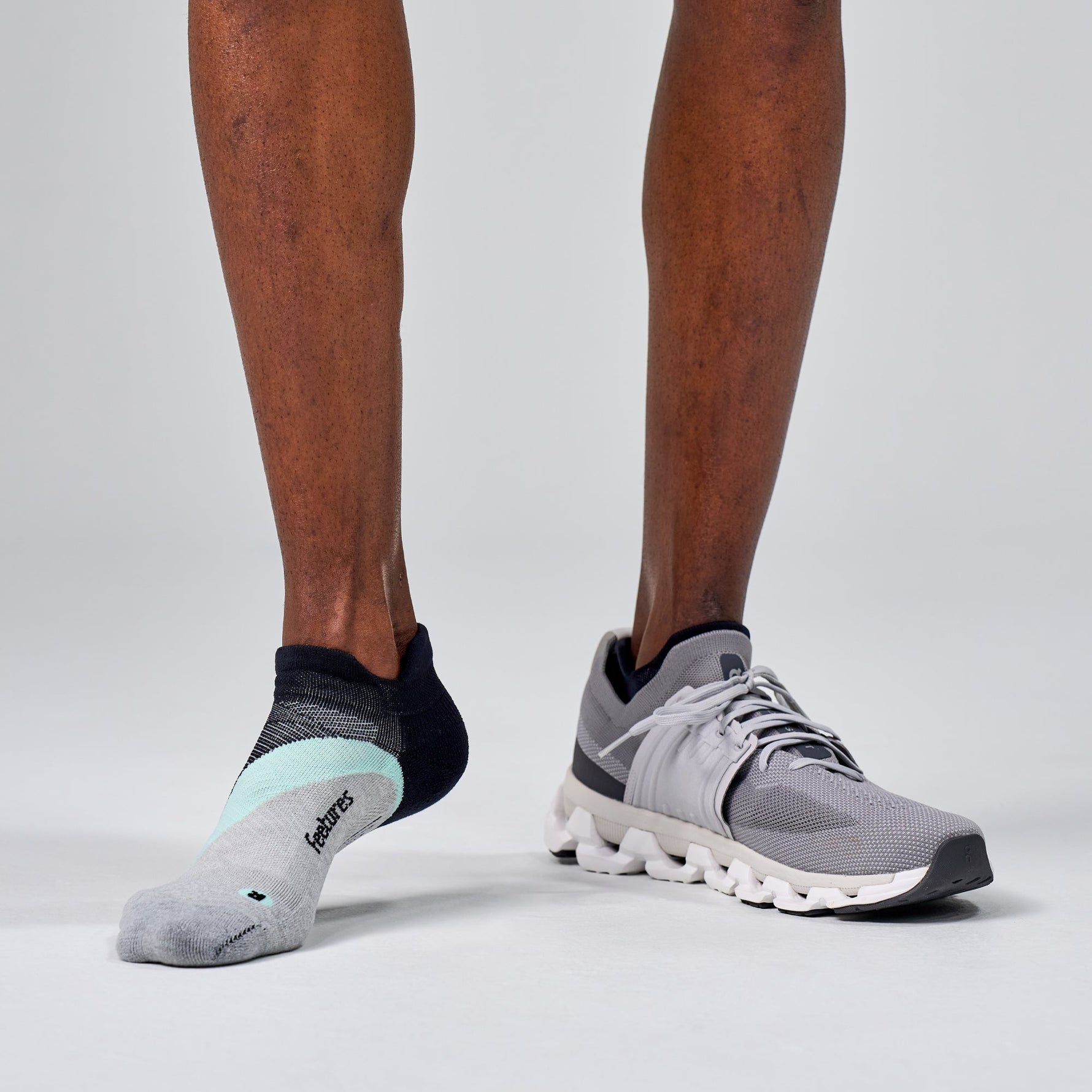 Feetures Elite Light Cushion Tab socks in Mint Chip worn with gray running shoes
