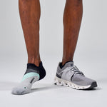 Feetures Elite Light Cushion Tab socks in Stone Ivy worn with gray running shoes