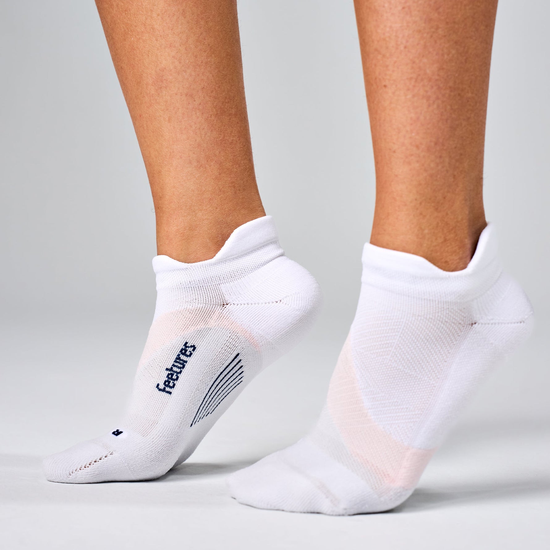 Feetures Elite Light Cushion Tab socks in white rose on model feet