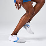 Feetures Elite Light Cushion Tab socks in white with blue accents on running athlete