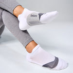 Feetures Elite Light Cushion Invisible white no-show socks worn on model feet