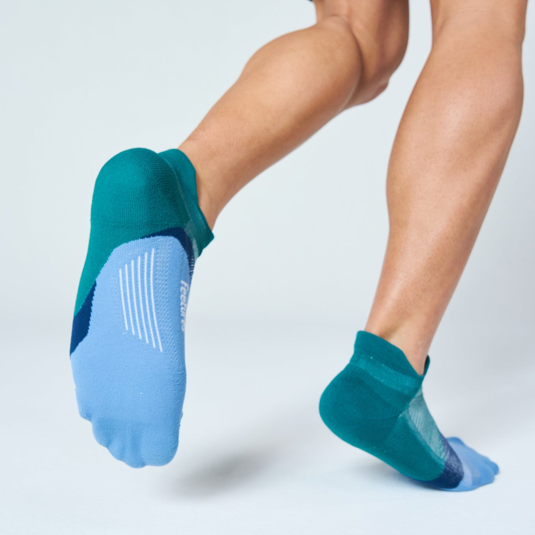 Feetures Elite Light Cushion Tab socks in Lilac Breeze teal and periwinkle colorway on athletic legs