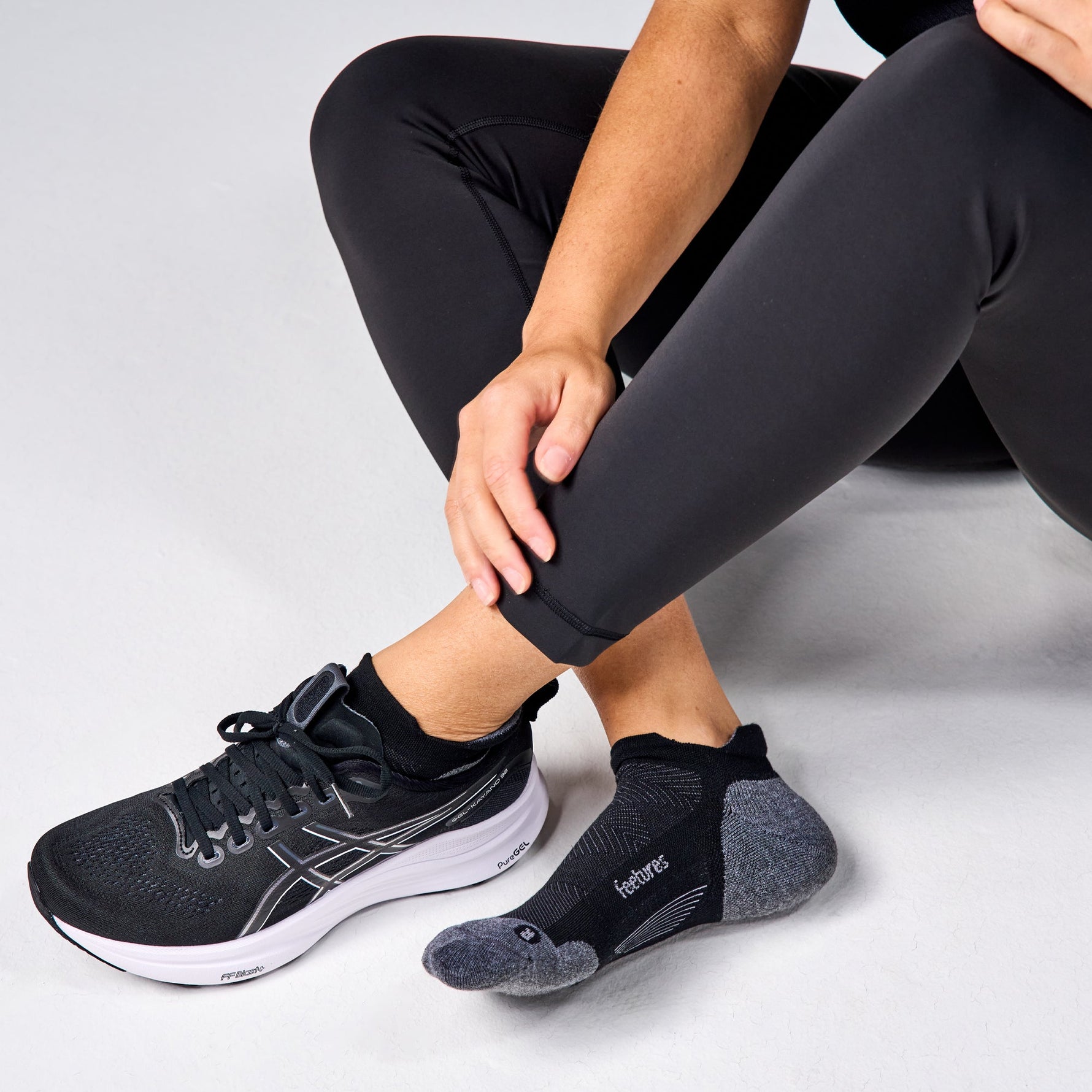 Feetures Elite Max Cushion Tab socks in basic grey worn with running shoes