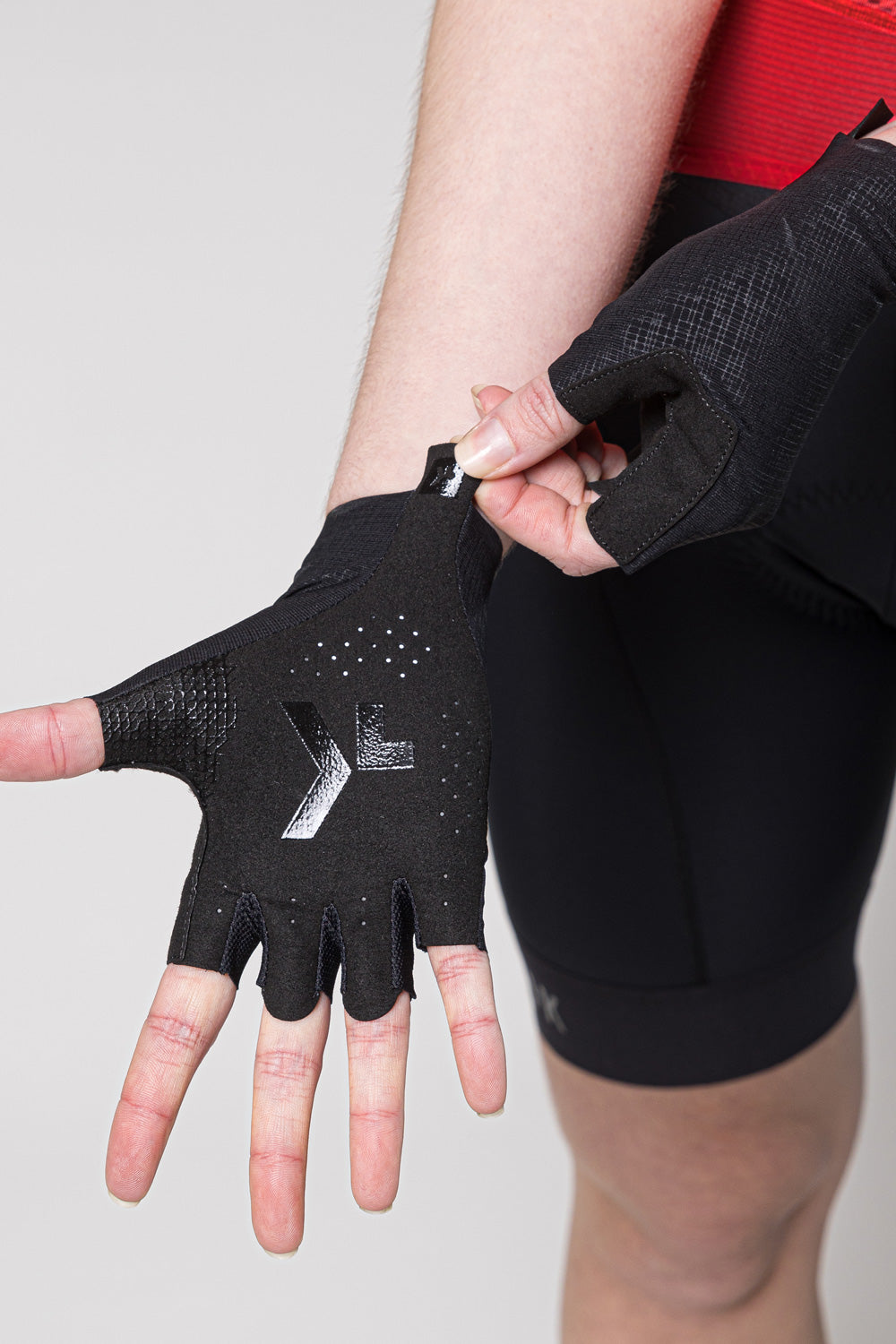Black fingerless cycling gloves with logo being worn by person
