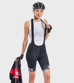 Woman wearing ALE cycling bibshort with white mesh tank top and bike helmet