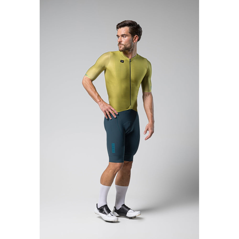 Man wearing Gobik Attitude 2.0 cycling jersey in split green colorway with matching shorts