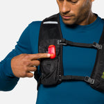 Man wearing chest pack demonstrating red Nathan LED safety light clip attachment
